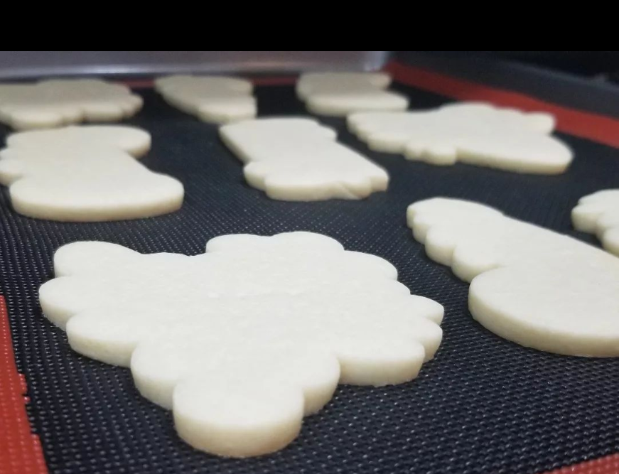 Baked sugar cookies on a perforated silicone baking mat